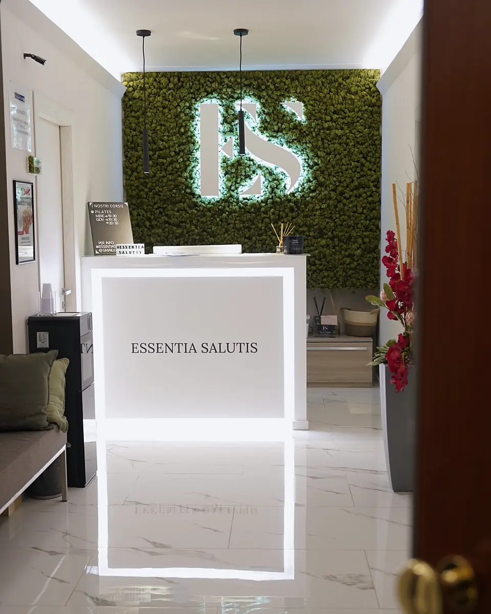 La reception di Via Salbertrand: il banco Essentia Salutis e il logo sulla parete di muschio.